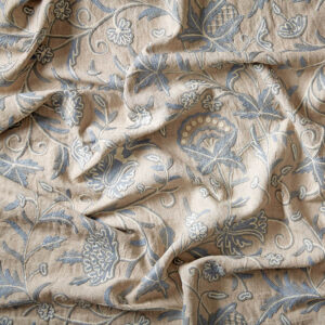 Blue and cream fabric. Floral embroidery on a stone linen background.