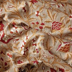 Red fabric, trailing flowers and leaves on a warm, natural linen background.