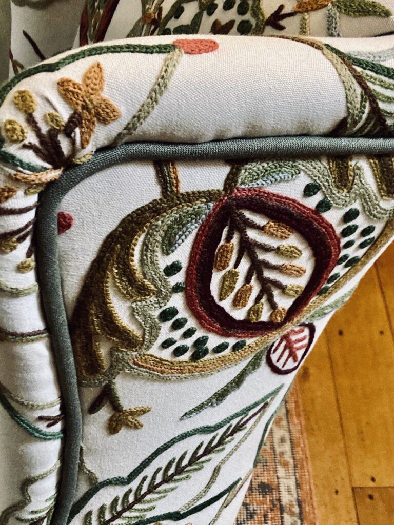 detail of chair upholstered in crewel fabric
